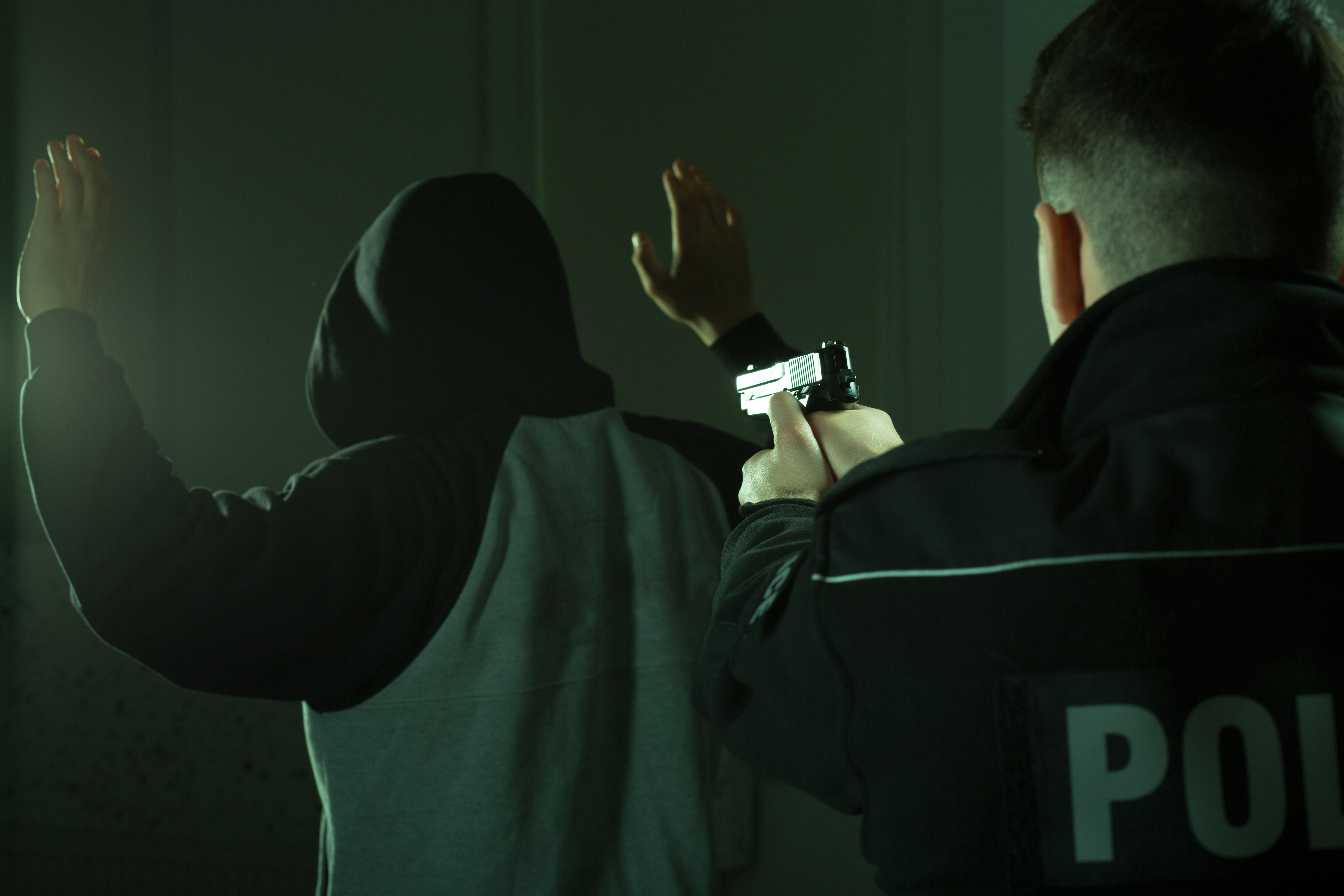 police officer pointing gun at criminal suspect