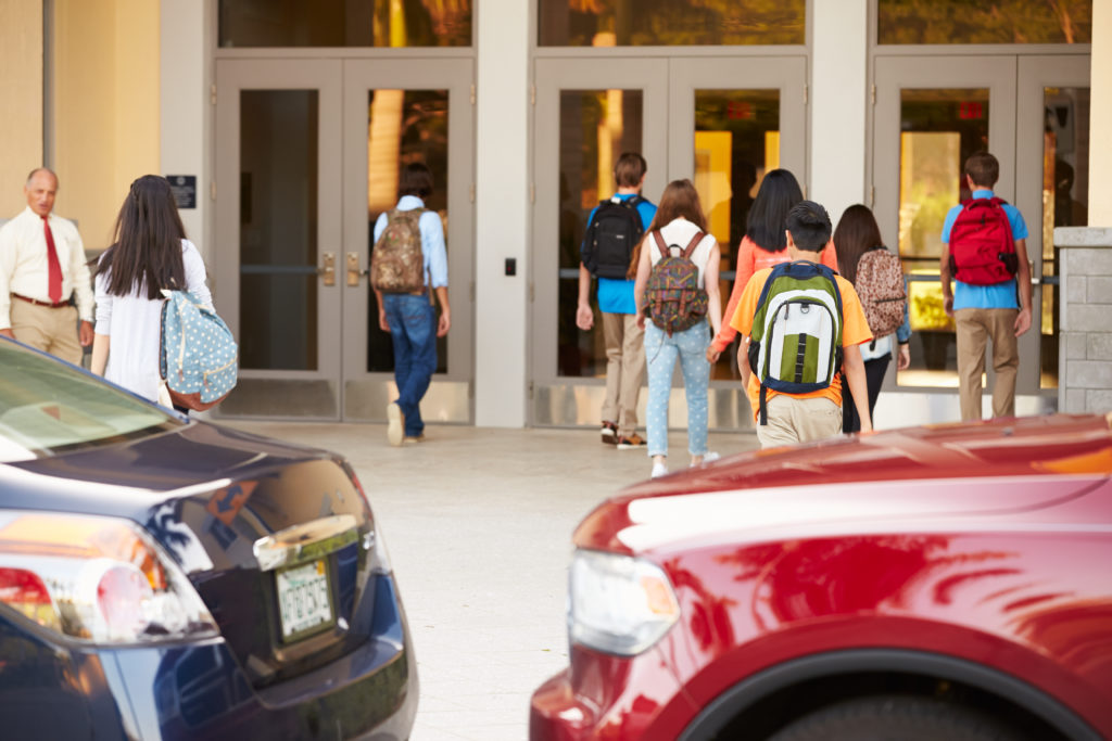 High School Students Being Dropped Off At School By Parents